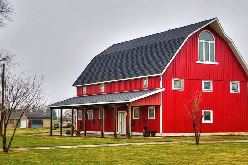 A bright red barn with a dark grey roof.