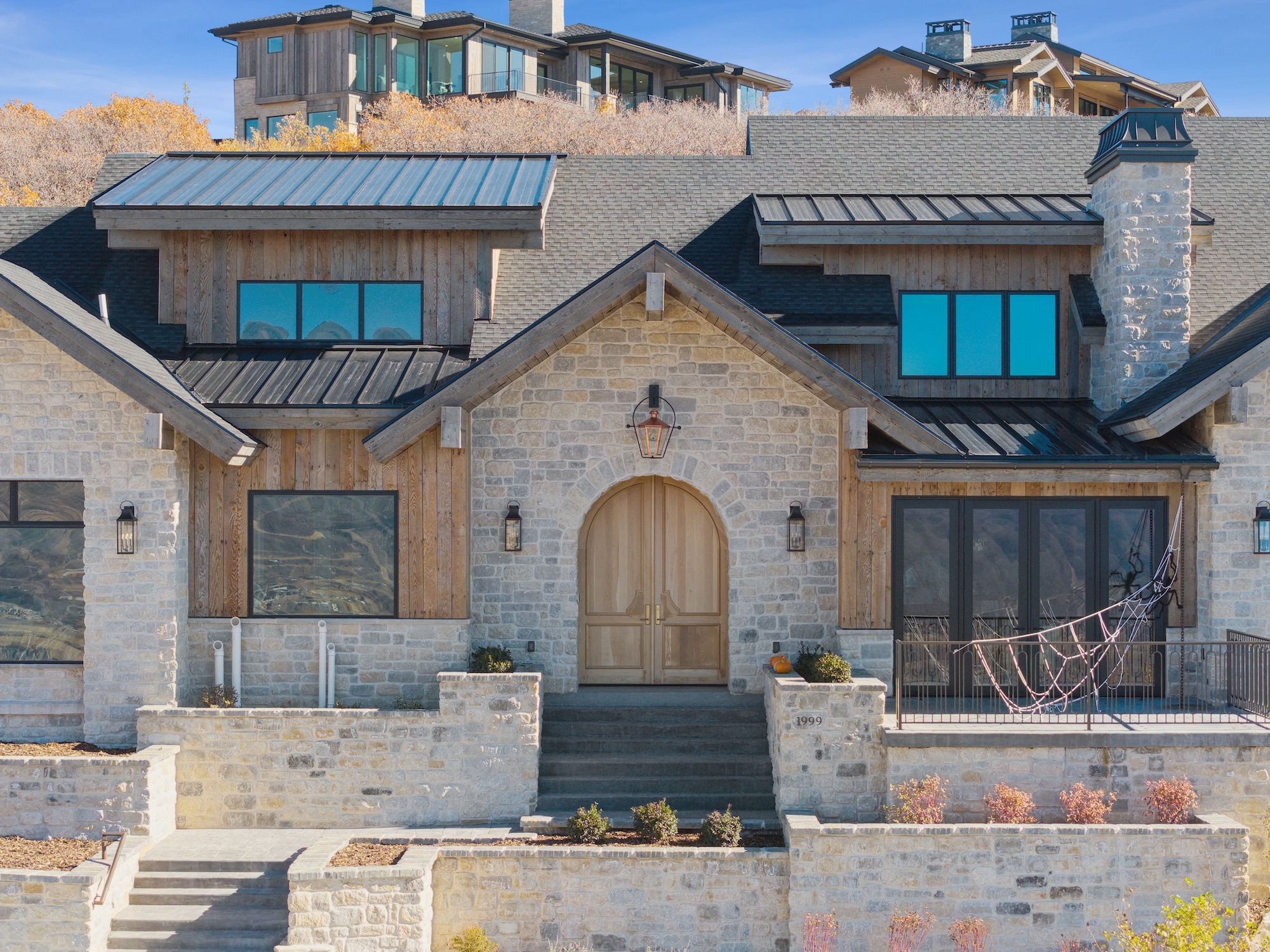 Front entry exterior photograph of a custom home with stone and wood details in Golden Eagle, Hideout, Utah.